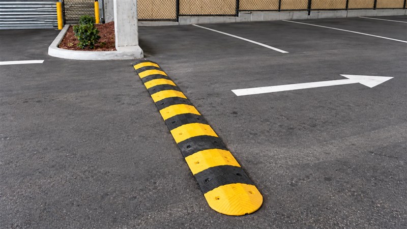 Yellow and black speed hump on a carpark