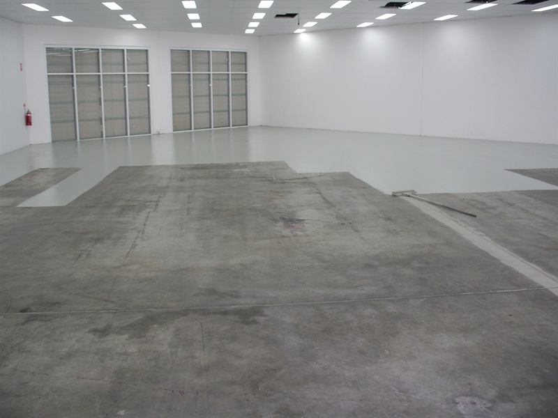 Showroom floor before: patchy bare concrete