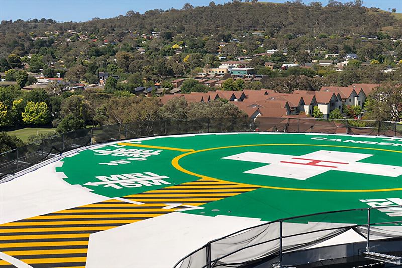 Green helipad and hazard-striped walkway