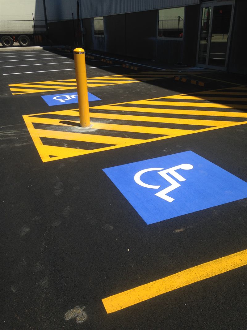 Disabled parking bay and yellow hatching linemarked on a carpark
