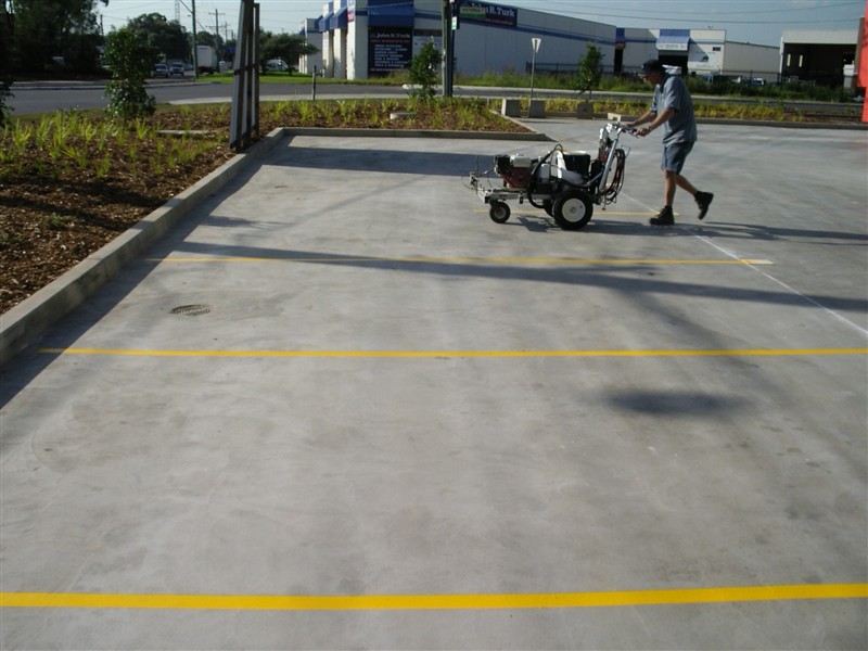Linemarking yellow bays on a new concrete carpark with a line marker