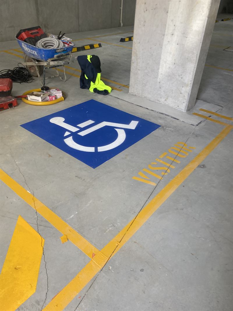 Accessible bay, visitor bay and hatching in a basement carpark