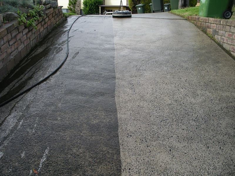 Exposed aggregate driveway half pressure cleaned, showing the clean and dirty sections side by side