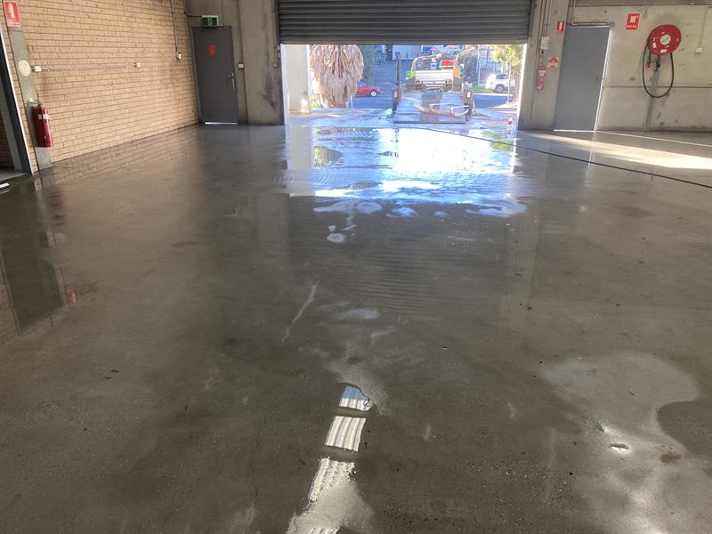 Rinsing a warehouse floor towards the roller door